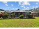 Well-maintained yard with green grass and a screened-in lanai at 18631 Le Dauphine Pl, Lutz, FL 33558