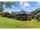 Beautiful backyard featuring a screened-in pool, lush landscaping, and green lawn at 18631 Le Dauphine Pl, Lutz, FL 33558
