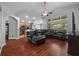 Open-concept living room with a ceiling fan, wood floors, and a large leather sectional at 18631 Le Dauphine Pl, Lutz, FL 33558