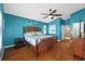 Tranquil main bedroom with blue walls, wood floors, ceiling fan and natural light at 18631 Le Dauphine Pl, Lutz, FL 33558