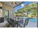 Relaxing screened patio featuring a table and chairs overlooking sparkling swimming pool at 18631 Le Dauphine Pl, Lutz, FL 33558