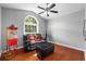 Cozy sitting room with hardwood floors, a plush black leather couch, and a large window at 18631 Le Dauphine Pl, Lutz, FL 33558