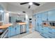 Light, open kitchen featuring butcher block counters, stainless dishwasher, bright blue cabinetry, and an open view to the living space at 2003 Cordova Grn, Seminole, FL 33777
