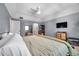 Spacious main bedroom featuring a ceiling fan, television, and ensuite bathroom with blue and white paint at 2003 Cordova Grn, Seminole, FL 33777