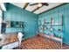 Unique home office featuring decorative wood-look flooring, teal-painted walls and wood shelving at 2003 Cordova Grn, Seminole, FL 33777