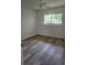 Bright bedroom with stylish wood-look flooring and a window offering natural light at 2293 Swedish Dr # 11, Clearwater, FL 33763