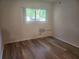 Bright bedroom with hardwood floors, large window, and neutral walls at 2293 Swedish Dr # 11, Clearwater, FL 33763