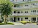 Building exterior featuring ample parking and a beautifully landscaped entrance at 2293 Swedish Dr # 11, Clearwater, FL 33763