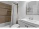 Bathroom featuring a shower-tub combination with white vanity and decorative mirror at 2916 W Crest Ave, Tampa, FL 33614
