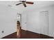 Hardwood floored bedroom with ceiling fan, closet and an open door to the living area at 2916 W Crest Ave, Tampa, FL 33614
