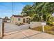 Charming home exterior with a screened porch, long driveway, and well-maintained landscaping at 2916 W Crest Ave, Tampa, FL 33614