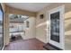 Screened front porch with red tile flooring, leading to the beautiful glass front door at 2916 W Crest Ave, Tampa, FL 33614