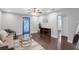 Bright living room featuring hardwood floors, stylish furniture, ceiling fan, and a unique blue door at 2916 W Crest Ave, Tampa, FL 33614