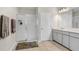 Bright bathroom showcasing tile flooring, glass-enclosed shower, white cabinets, and ample counter space at 29901 Southwell Ln, Wesley Chapel, FL 33543