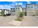 Home exterior with individual garages, neutral stucco, front yard landscaping, and paver driveway with parked car at 29901 Southwell Ln, Wesley Chapel, FL 33543