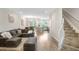 Open-concept living area with hardwood floors seamlessly connecting the living room, dining area, and kitchen at 29901 Southwell Ln, Wesley Chapel, FL 33543