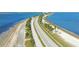 Aerial view of a causeway featuring palm trees and a road bordered by water and sandy shores at 3010 Beecher E Dr # A, Palm Harbor, FL 34683