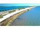 Aerial view of the Dunedin Causeway with palm trees lining the road alongside the beach and blue ocean at 3010 Beecher E Dr # A, Palm Harbor, FL 34683