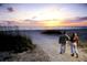 Beautiful beach with people walking along the shore at sunset at 3010 Beecher E Dr # A, Palm Harbor, FL 34683