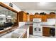 Bright kitchen features tile flooring, white appliances, and solid countertops at 3010 Beecher E Dr # A, Palm Harbor, FL 34683
