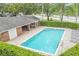 Community pool with brick patio, shaded seating, and convenient access to community building at 3010 Beecher E Dr # A, Palm Harbor, FL 34683