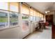 Well-lit sunroom featuring tiled floors, large windows with backyard views, and dining and workspace areas at 3010 Beecher E Dr # A, Palm Harbor, FL 34683