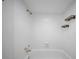 All-white bathroom featuring a bathtub, tiled walls, and bronze shower fixtures at 3038 Eastland Blvd # F102, Clearwater, FL 33761