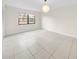Bright bedroom with ceramic tile flooring and large window letting in natural light at 3038 Eastland Blvd # F102, Clearwater, FL 33761
