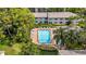 Aerial view of a pool surrounded by chairs and lush landscaping at 3038 Eastland Blvd # F102, Clearwater, FL 33761