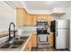 Cozy kitchen with stainless steel appliances, wood cabinets, and neutral countertops at 307 Francis Dr, Apollo Beach, FL 33572