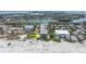 Aerial view of beachfront building, showcasing its proximity to the water and nearby bridge and cityscape at 3200 Gulf Blvd # 202, St Pete Beach, FL 33706