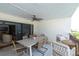 Inviting outdoor balcony with a large table, stylish seating, and a ceiling fan for comfortable lounging at 3200 Gulf Blvd # 202, St Pete Beach, FL 33706