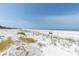 Beautiful view of a wide sandy beach with clear blue skies and tranquil ocean waters at 3200 Gulf Blvd # 202, St Pete Beach, FL 33706