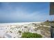 Expansive view of the white sandy beach and calm ocean waters, perfect for relaxation and enjoying the coastal scenery at 3200 Gulf Blvd # 202, St Pete Beach, FL 33706