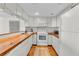 Efficient kitchen layout with wooden countertops and modern white appliances at 3200 Gulf Blvd # 202, St Pete Beach, FL 33706