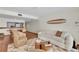 Cozy living room with modern decor, wood floors, surfboard art and open dining area at 3200 Gulf Blvd # 202, St Pete Beach, FL 33706