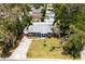 An aerial view shows the quaint home nestled amongst mature trees with a long driveway at 3245 Freemont S Ter, St Petersburg, FL 33712