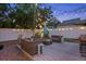 This backyard features a patio with outdoor seating, an umbrella, string lights, and a white fence, creating a cozy atmosphere at 3245 Freemont S Ter, St Petersburg, FL 33712