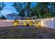 Outdoor entertainment area with string lights, a hammock, and a white privacy fence, creating a relaxing backyard retreat at 3245 Freemont S Ter, St Petersburg, FL 33712