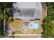 Aerial view of backyard featuring a deck, a fire pit, decorative rocks, and a patio seating arrangement with a bright blue umbrella at 3245 Freemont S Ter, St Petersburg, FL 33712