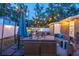 Outdoor living space featuring a cozy patio with lounge seating, fire pit, overhead string lights, and privacy fence, ideal for entertaining at 3245 Freemont S Ter, St Petersburg, FL 33712