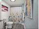 Stylish bathroom features wood-look flooring, a shower with floral curtains, and modern fixtures at 3245 Freemont S Ter, St Petersburg, FL 33712