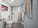 This bathroom features plank walls, a toilet, a tub and shower combination, and unique artwork at 3245 Freemont S Ter, St Petersburg, FL 33712