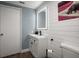 This bathroom features plank walls, a toilet, a modern sink, a mirror with lighting, and a unique artwork at 3245 Freemont S Ter, St Petersburg, FL 33712