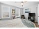 Bright bedroom with a ceiling fan, two windows, a lounge chair, a television, and minimalist decor at 3245 Freemont S Ter, St Petersburg, FL 33712