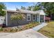 Charming home exterior with a well-manicured lawn, decorative tree, and a welcoming blue front door at 3245 Freemont S Ter, St Petersburg, FL 33712