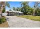Wide shot of the exterior of the home with a long driveway and mature trees surrounding the property at 3245 Freemont S Ter, St Petersburg, FL 33712