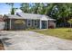 Exterior of the home showing the gray facade, trimmed lawn, colorful shrubbery, and a blue front door at 3245 Freemont S Ter, St Petersburg, FL 33712