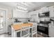Cozy kitchen with white cabinetry, stainless steel appliances, and a butcher block island at 3245 Freemont S Ter, St Petersburg, FL 33712