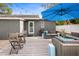Inviting backyard patio with a seating area, grill, and table, shaded by a large blue umbrella at 3245 Freemont S Ter, St Petersburg, FL 33712